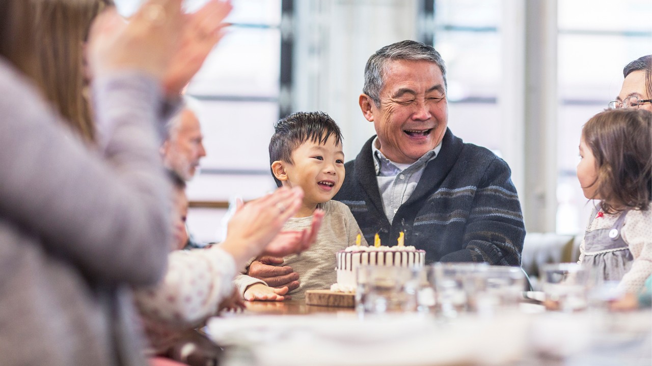 Family celebrating senior man's birthday.