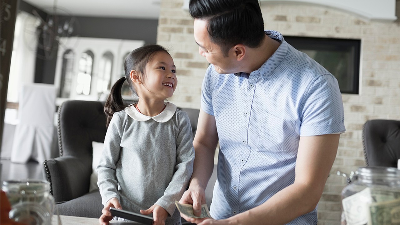  A father is teaching his daughter counting money.