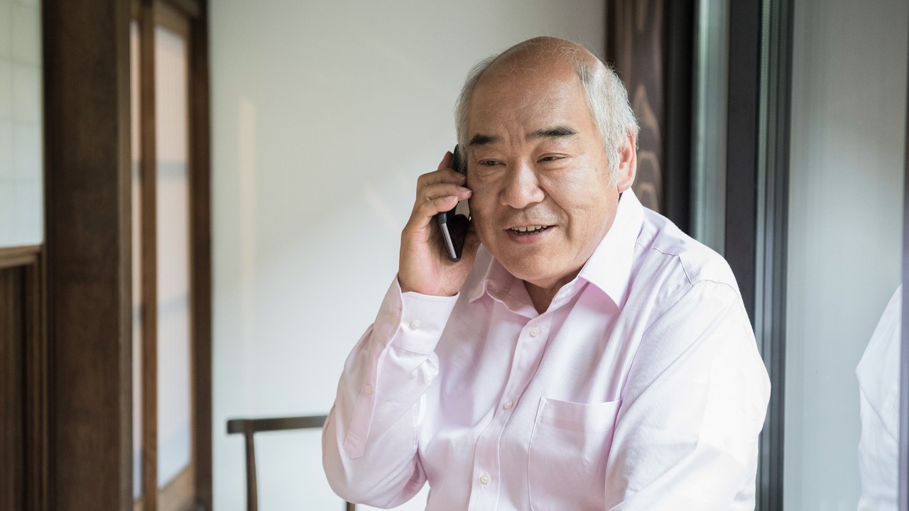A old man is talking on phone; image used for HSBC Singapore Insurance Submit a claim.