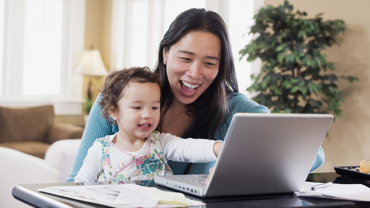Mother and baby look at screen of notebook computer; image used for HSBC Online Protector Insurance