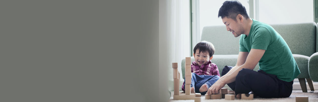 Father and son playing with building blocks together; image used for HSBC Life Protect Advantage II.
