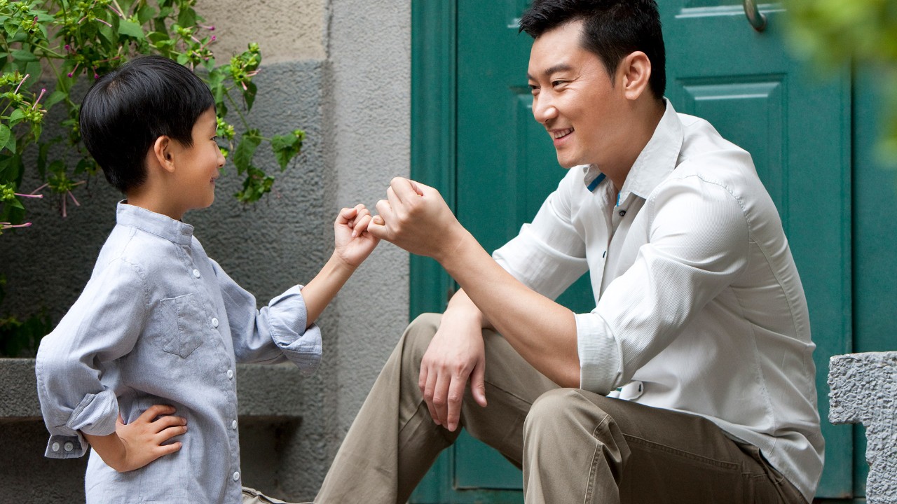 A father and son are making a pinky promise; image used for HSBC Savings Protector Plan Insurance.