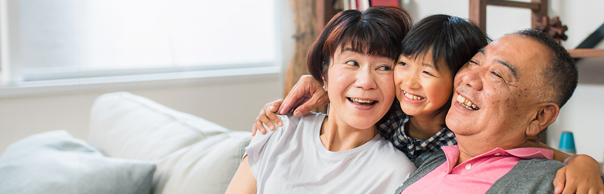 A happy family smiling on sofa; image used for HSBC Singapore Insurance Savings.